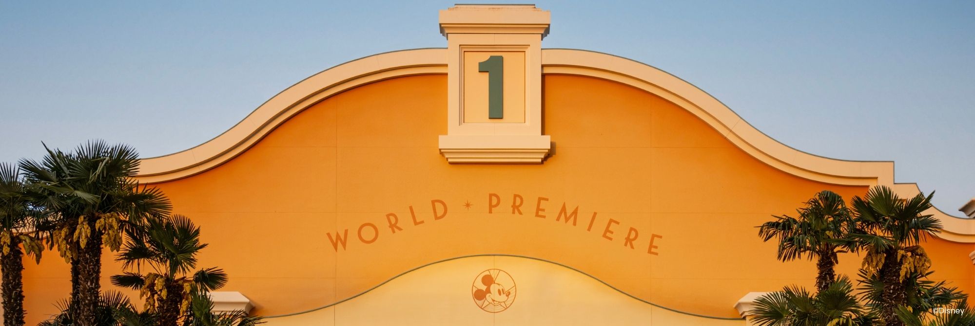 Geel entreegebouw van World Premier omringd door palmbomen
