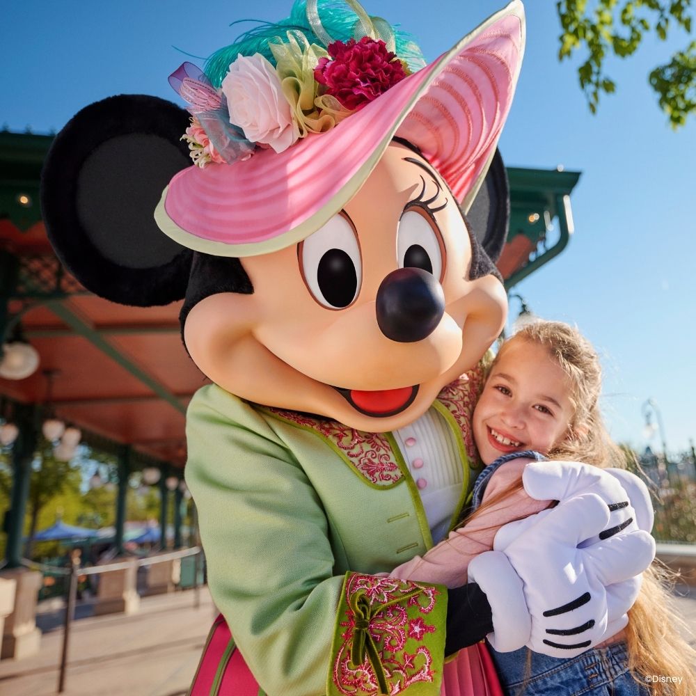Minnie Mouse in haar kleurrijke victoriaanse kleding met een hoef met bloemen tijdens een ontmoeting