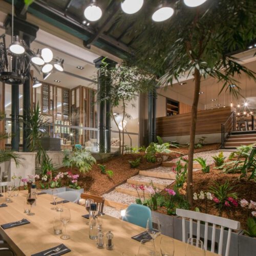 Le George Eettafel omring door bruin zand met groene bomen en planten