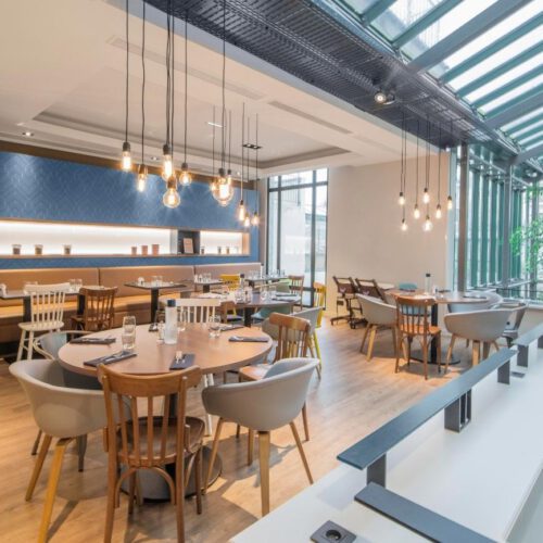 Restaurant boven Sfeervol restaurant met een boom en ronde houten tafels