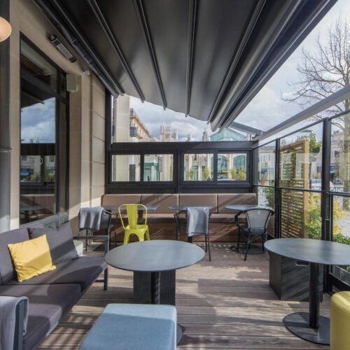 Terras Terras met grijze tafels en groene stoelen