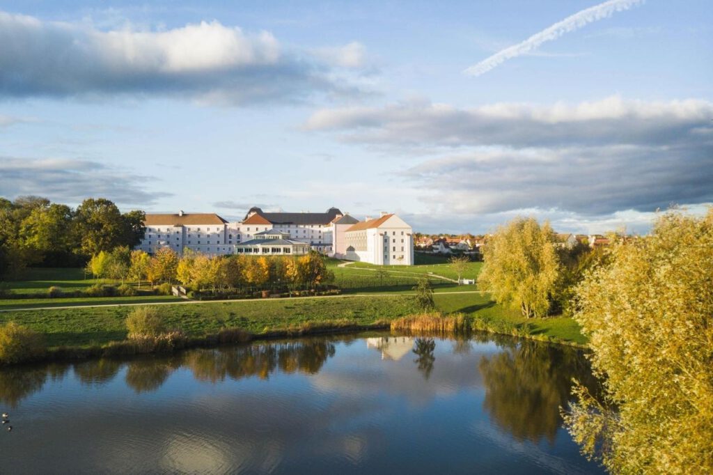 B&B hotel met witte gebouwen en een groot meer met grasveld