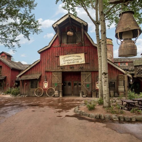 Cowboy Cookout Het roodgeschilderde gebouw van het restaurant Cowboy Cookout in Frontierland, met de uitstraling van een klassieke westernschuur.
