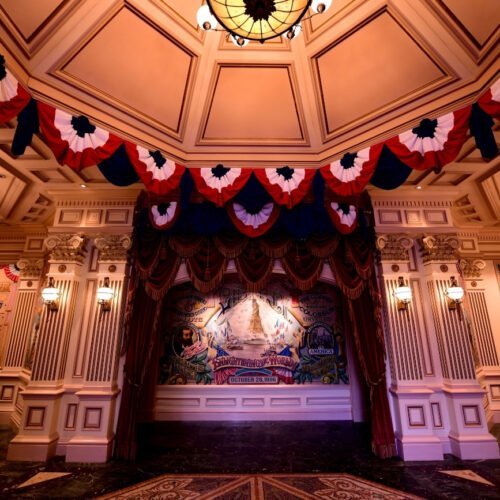 Arcade Main Street Victoriaanse details en tekeningen in Liberty Arcade, met sfeervolle verlichting en vlaggen die rondom een plafondlijst hangen.