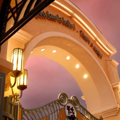 Entree Walt Disney Studios Park Gele entreeboog van Walt Disney Studios Park, verlicht met fonkelende lampjes in de schemering.