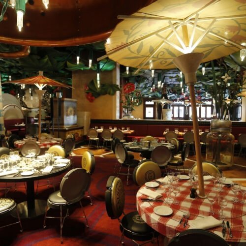 Chez Remy Restaurant Vrolijke tafels, stoelen en een paraso met lampjesl in het restaurant Chez Remy in Worlds of Pixar