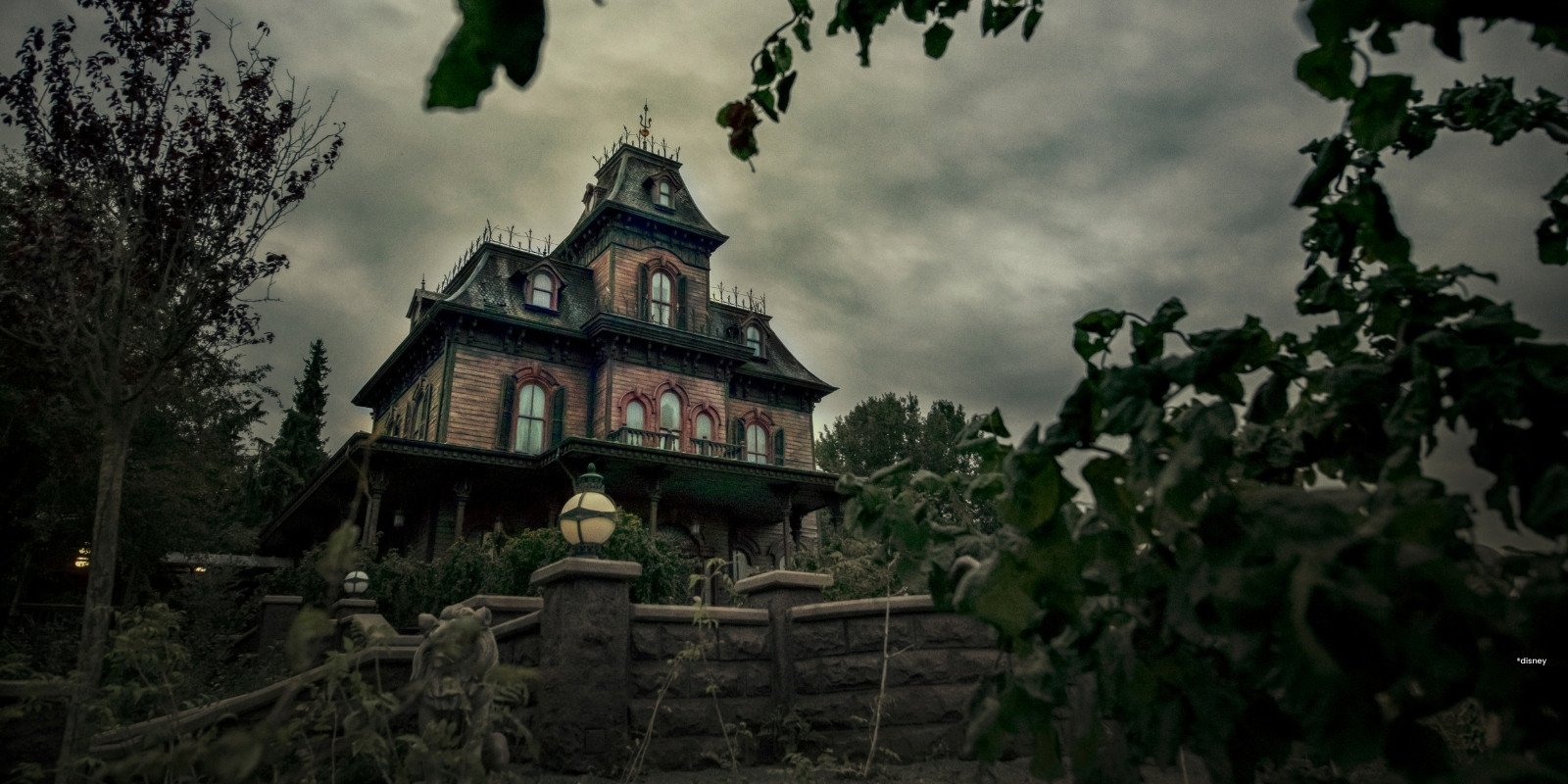 Spookhuis Phantom Manor in een groene omgeving met een bewolkte grijze lucht