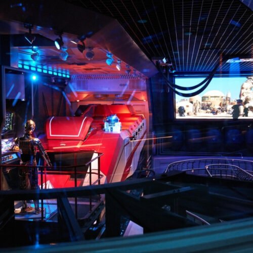 Star Tours attractie Rode simulator met daarvoor een robot in de wachtrij van de Star Tours Attractie