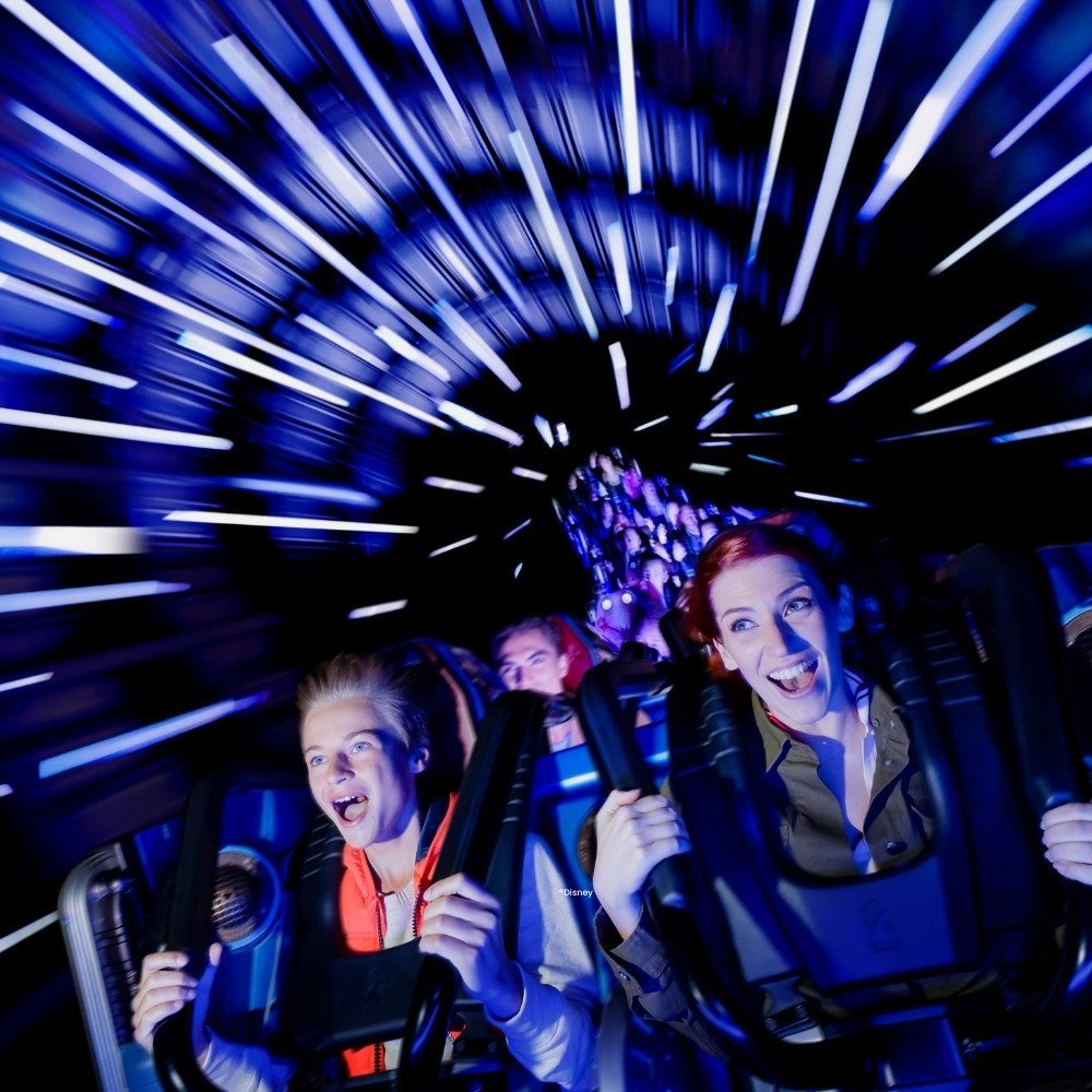 Mensen omringd door lampjes in Star Wars Hyperspace Mountain achtbaan