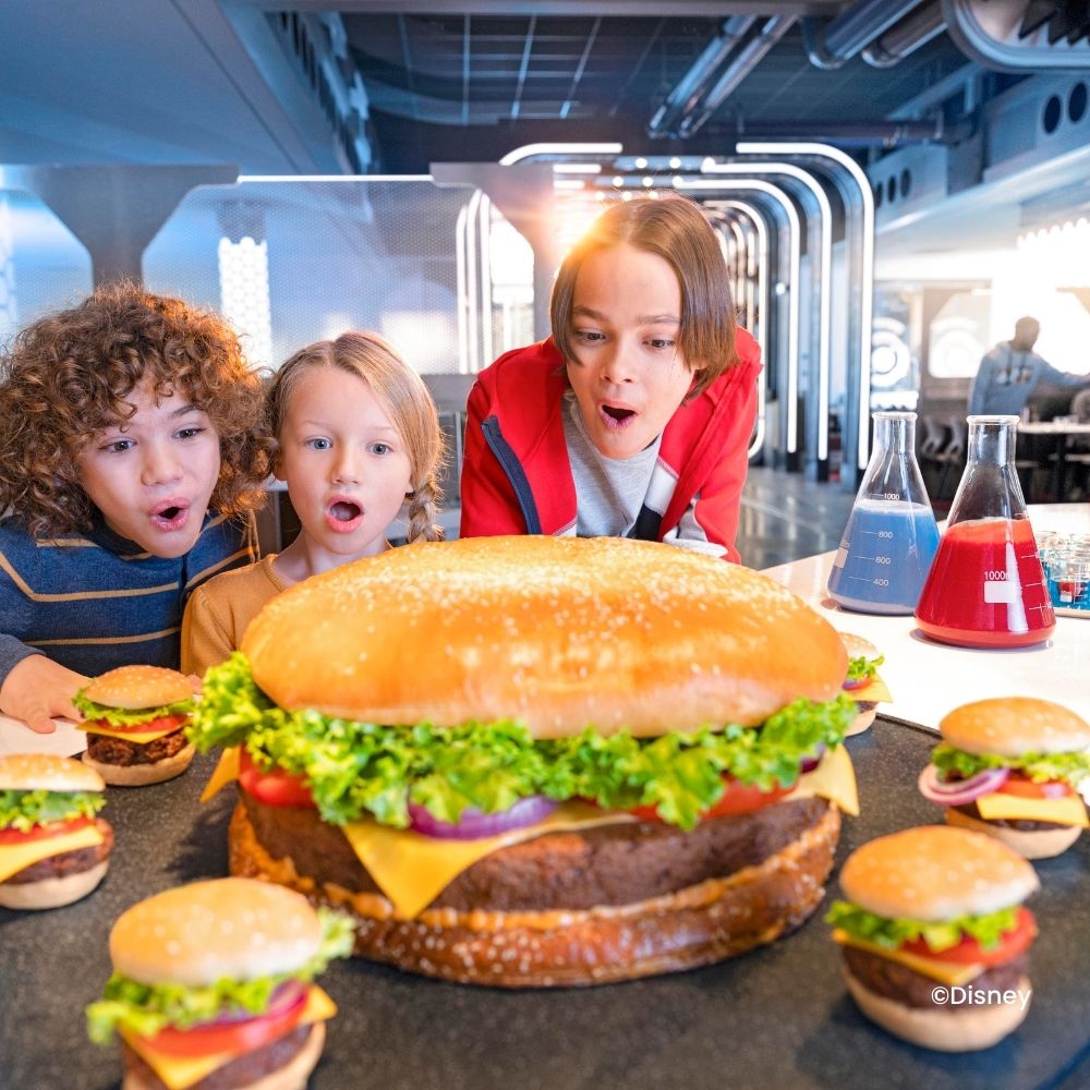 Levensgrote hamburger met 3 verbaasde kinderen in een Disneyland® Paris restaurant