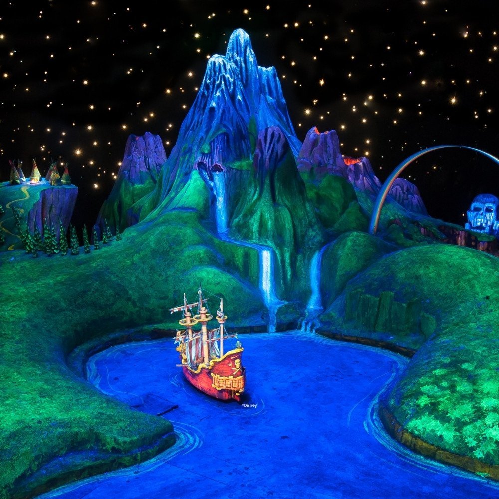 Piratenschip van Kapitein Haak in het water tussen de bergen van Nooitgedachtland in de attractie Peter Pan's Flight