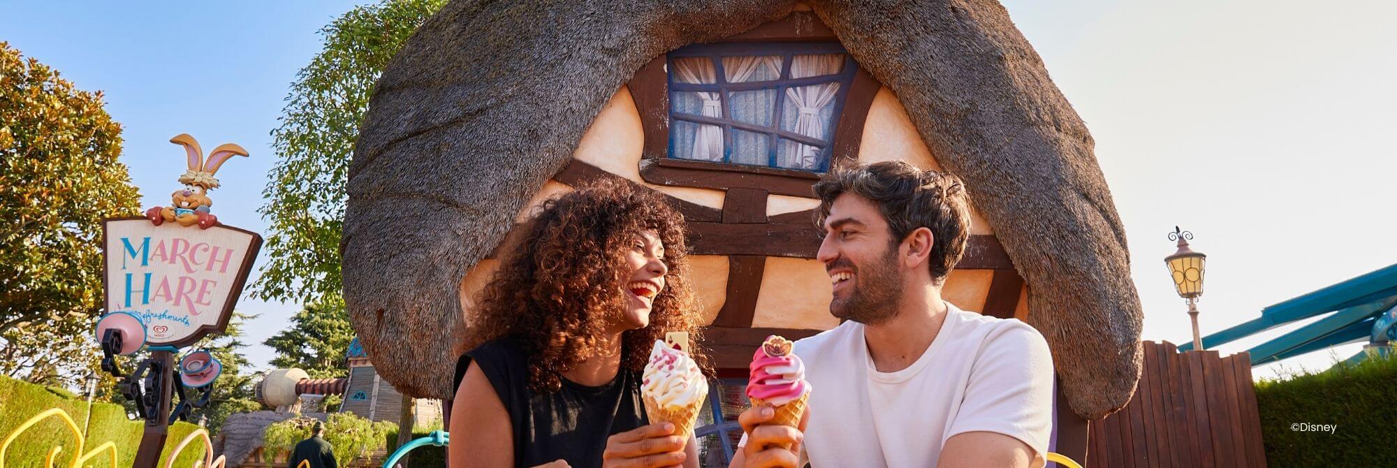 Mensen zitten in de zon en genieten van een ijsje in een van de Disney® Parken