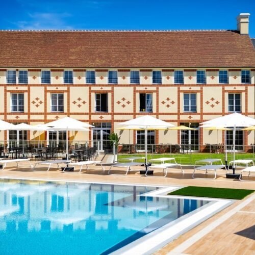 Staycity Aparthotel Buitenzwembad en witte parasols en ligbedden bij het Staycity Aparthotel Partner hotel Disneyland Paris