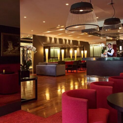 Loungebar hotel Bar met rode fauteuils en ronde tafels